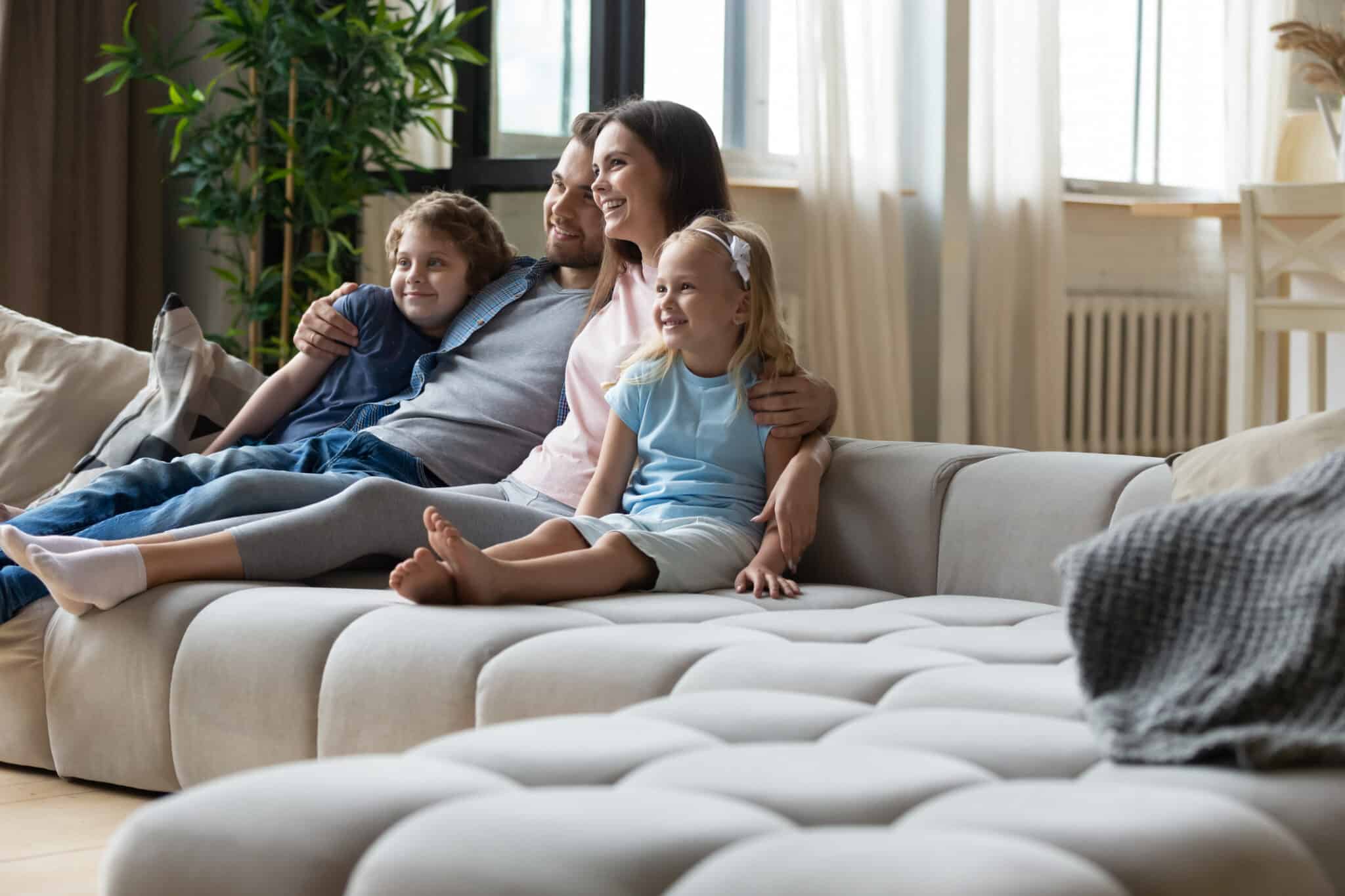 Happy young family with small kids sit relax on comfortable couch in living room, Air Purifiers.