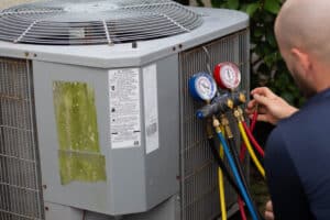 Closeup shot of AC Mechanic working on an AC outdoors air-conditioner, Heating and Cooling.